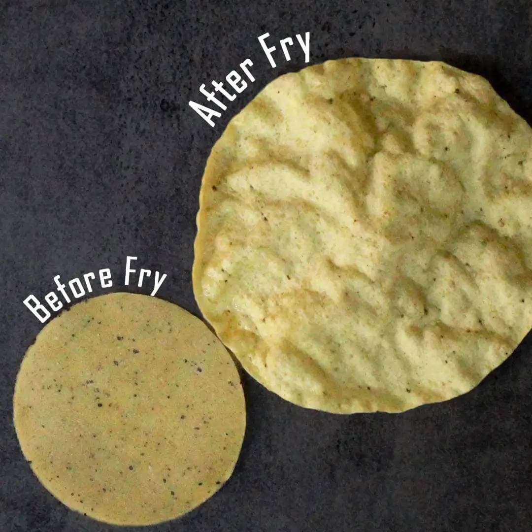 Close up of peppercorn infused urad dal papads with visible black pepper specks